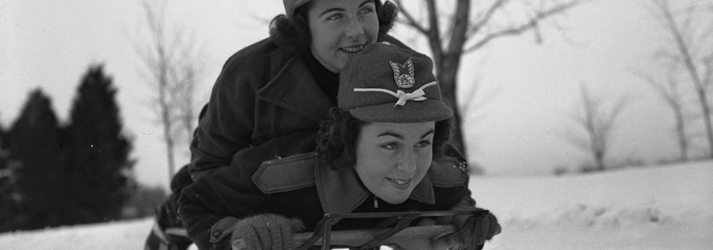 Photograph of Two Girls Sledding in Snow by Witman