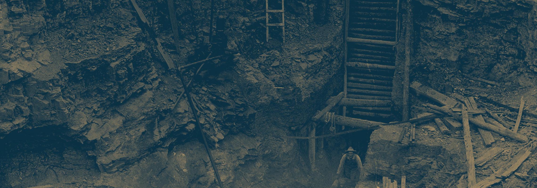 two men with wheelbarrows coming out of coal mine