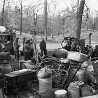 Displaced sharecropper families and their belongings sit along a road.